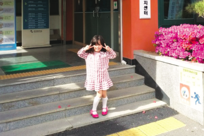 큰 아이가 보건소 건물 앞에서 포즈를 취하고 있다.